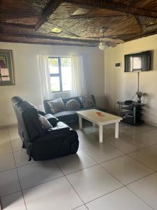 a living room with a couch and a table at Ufudu Chalet in Mbazwana