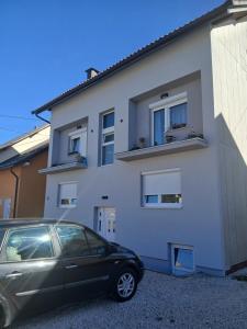 a car parked in front of a white house at Vinara Kupres in Kupres
