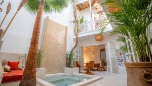 ein Wohnzimmer mit einem Pool und Palmen in der Unterkunft Riad Dar Zioui in Marrakesch