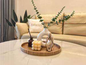 a wooden tray with a vase and candles on a table at R&F Princess Cove 2BR Sea View JB-SG Spacious in Johor Bahru