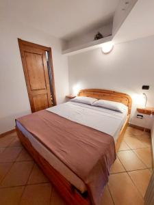 een slaapkamer met een groot bed met een houten hoofdeinde bij Lo chalet di Lucky in Campodolcino