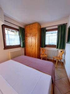 een slaapkamer met een bed en 2 stoelen. bij Lo chalet di Lucky in Campodolcino