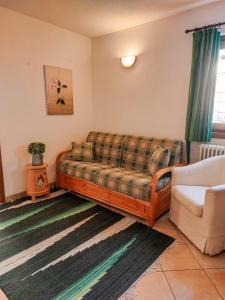 een woonkamer met een bank en een stoel bij Lo chalet di Lucky in Campodolcino