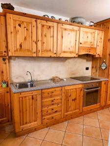 een keuken met houten kasten en een spoelbak bij Lo chalet di Lucky in Campodolcino