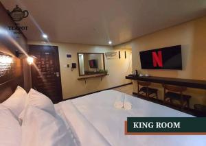 um quarto king com cama king size e escrivaninha em The Teapot Hotel em Naga