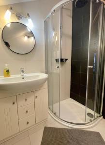 a bathroom with a shower and a sink and a mirror at Chalet Lomnica in Veľká Lomnica +15 photos
