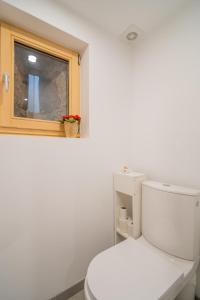 Un baño con inodoro blanco y ventana. en Au Stammtisch - Cozy, rustic and authentic, en Scherwiller