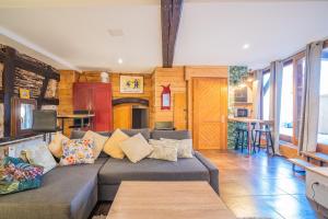 una sala de estar con un sofá y una mesa en Au Stammtisch - Cozy, rustic and authentic, en Scherwiller