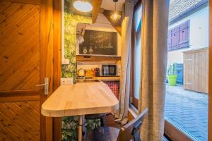 cocina con mesa de madera y encimera en Au Stammtisch - Cozy, rustic and authentic, en Scherwiller
