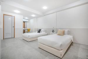 a white bedroom with two beds and a couch at Haus Ekkamai 2 in Khlong Toei +72 photos