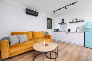 un salon avec un canapé et une table dans l'établissement SARNIA HQ Container House in Bielsko-Biała with Garden and Air Conditioning by Noclegi Renters, à Bielsko-Biała