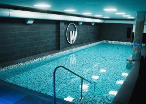 a large swimming pool in a room with a mirror at Hôtel Saint Christophe Aix en Provence Centre Ville in Aix-en-Provence