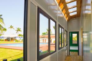 un couloir avec des fenêtres donnant sur une piscine dans l'établissement Lumiere Family Village Đông Tác, à Hiếu Xương