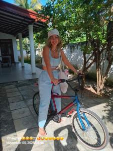 a woman is standing next to a bike at Mihinsa Guest in Kosgoda