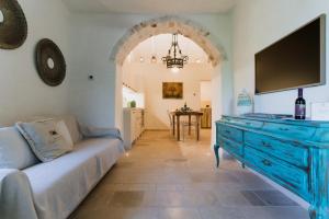 a living room with a blue dresser with a flat screen tv at Trulli Ad Maiora in Alberobello