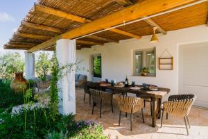 a patio with a table and chairs under a wooden ceiling at Trulli Ad Maiora in Alberobello