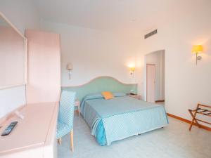 a bedroom with a bed and two blue chairs at Hotel Splendid in Diano Marina