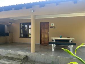 a patio with a bench and a table and a door at Ingwenya Chalet in Sodwana Bay