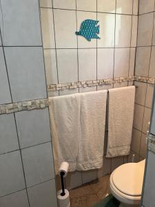a bathroom with white towels and a blue fish on the wall at Ingwenya Chalet in Sodwana Bay +6 photos