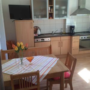 a kitchen with a table with a vase of flowers on it at Ferienhof Christmann in Mossautal
