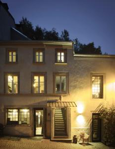 a building with a staircase in front of it at night at Studio Beim Mulles 'Schapp' in Vianden