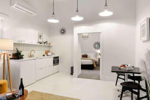 a kitchen and living room with a table and a room at Apartment 22 - stylish retreat in central location in Fitzroy