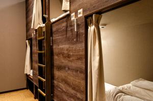 奈良bnbplus Sarasa Nara的带床和木墙的卧室