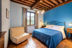 ein blaues Schlafzimmer mit einem Bett und einem Stuhl in der Unterkunft Il Castagno Toscana in Campiglia Marittima + 63 Fotos