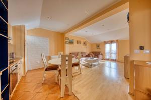 een keuken en woonkamer met een tafel en stoelen bij Apartments Kristić in Dubrovnik +28 foto's
