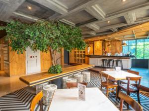 a restaurant with tables and a tree in the middle at Oria Hotel Jakarta in Jakarta