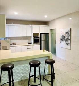 a kitchen with two bar stools and a counter at JM House Kuala Lumpur in Puchong