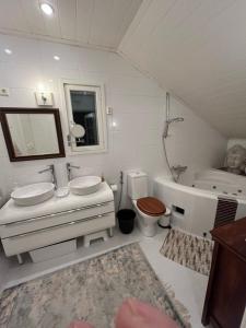ein Badezimmer mit zwei Waschbecken und einer Badewanne und einer Toilette in der Unterkunft Wonderful townhouse 214 m2 close to outdoor areas in Helsinki