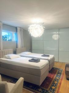 ein Schlafzimmer mit einem großen Bett und einem Kronleuchter in der Unterkunft Wonderful townhouse 214 m2 close to outdoor areas in Helsinki