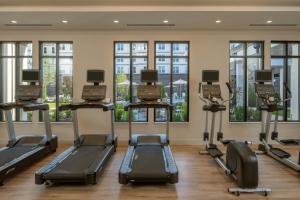 ein Fitnessstudio mit Laufbändern und Crosstrainern und Fenstern in der Unterkunft Residence Inn Atlanta Buckhead/Lenox Park in Atlanta