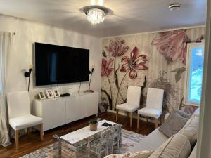 ein Wohnzimmer mit Fernseher, Couch und Sesseln in der Unterkunft Wonderful townhouse 214 m2 close to outdoor areas in Helsinki