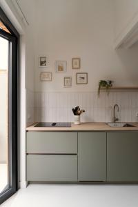 a kitchen with white cabinets and a sink at Beachhouse SeaBreeze - vernieuwd! in Noordwijk