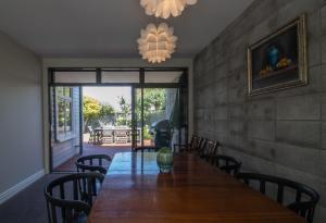 a dining room with a wooden table and chairs at Fabulous In Fitzroy - seconds to Fitzroy Beach in New Plymouth