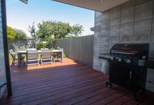 a patio with a grill and a table and chairs at Fabulous In Fitzroy - seconds to Fitzroy Beach in New Plymouth +14 photos