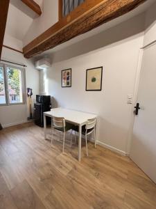 a dining room with a white table and chairs at Duplex refait à neuf - Pibrac, proche Colomiers in Pibrac