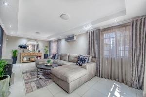 a living room with a couch and a table at White Rose Villa in Gaborone