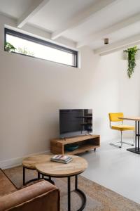 a living room with a tv and a table at Beachhouse SeaBreeze - vernieuwd! in Noordwijk