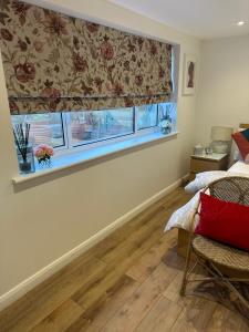 - une chambre avec une fenêtre dotée d'un rideau et d'une chaise dans l'établissement Glastonbury Vista, à Glastonbury