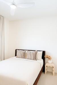 アレクサンドラ・ヘッドランドにあるBeachfront Penthouse With Uninterrupted Ocean Viewsの白い壁のベッドルームのベッド1台