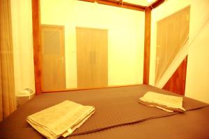 a room with a bed with two towels on it at Peak House in Hiriketiya +91 photos