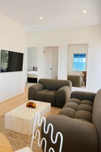 アレクサンドラ・ヘッドランドにあるBeachfront Penthouse With Uninterrupted Ocean Viewsのソファ2つとテレビのあるリビングルーム