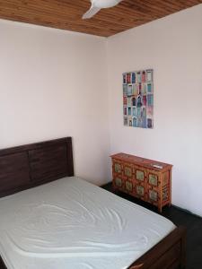 Un dormitorio con una cama y un cuadro en la pared. en Kaze paradis, en Saint-Pierre