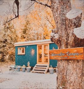 a blue house with a sign on a tree at Worcester Escape in Hallow