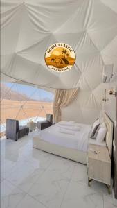 DisahRUM ROYAL CLASSIC lUXURY CAMP的一间白色的卧室，帐篷里有一张床