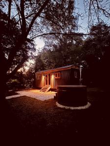 a small cabin with a lighted door in a yard at Worcester Escape in Hallow +18 photos