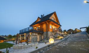 a large log house with a driveway at Widokowa Chata Istebna Trójwieś in Istebna